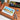 Size 10 Round Detail Travel Watercolor Brush beside a portable wooden watercolor paint set and a cityscape painted on 100% cotton cold press watercolor paper, ideal for professional artists and travel sketching.
