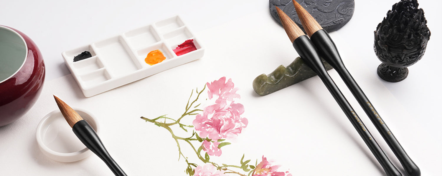 Chinese Calligraphy Brush set with natural bristles used on white paper for flower painting, featuring a white ceramic palette with watercolor paint and a traditional brush rest for professional artists.