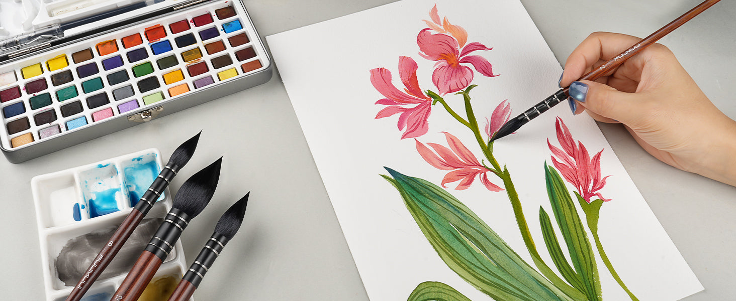 Professional artist using Fuumuui Squirrel Hair Watercolor Brushes in sizes 2, 6, and 12 to paint pink flowers on textured Cold Press paper. Set includes a large metal Watercolor Paint Set and ceramic palette.