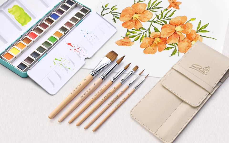 Squirrel Hair Watercolor Brush set with sizes 0 to 12 and a leather pouch. Professional Artist tools shown with a metal Watercolor Paint Set and orange floral painting on 100% Cotton Cold Press paper.