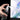 Fuumuui Pressureless Spray Bottle held in hand, spraying a fine mist from the clear bottle, against a vibrant floral watercolor background.