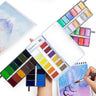 Set di pittura ad acquerello a 60 colori Fuumuui aperto, che mostra la sua gamma completa di colori vivaci su tavolozze compatte, con un artista che dipinge arte ad acquerello.