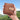 Compact brown leather Travel Palette case for a watercolor paint set or travel brushes, held against a mountain landscape, perfect for professional artists and beginners for plein air painting and sketching.