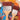 Fuumuui 2pcs Large Nylon Flat Brushes (80mm and 50mm) with wooden handles and brown synthetic bristles, lying on a colorful artist's palette filled with paint for Watercolor, Acrylic & Oil Painting.