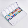 Ensemble de peinture aquarelle 24 couleurs Fuumuui ouvert dans une boîte turquoise, présentant des peintures vibrantes et scintillantes avec une palette de mélange intégrée.