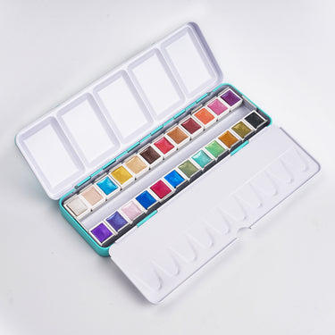 Ensemble de peinture aquarelle 24 couleurs Fuumuui ouvert dans une boîte turquoise, présentant des peintures vibrantes et scintillantes avec une palette de mélange intégrée.