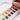 Fuumuui Portable 12-color solid watercolor paint set. A hand uses the included brush to activate an orange artist-grade watercolor pan from the Fuumuui art supplies kit. This set features a palette, transparent and clean layers, and a refined formula with no chalky finish.