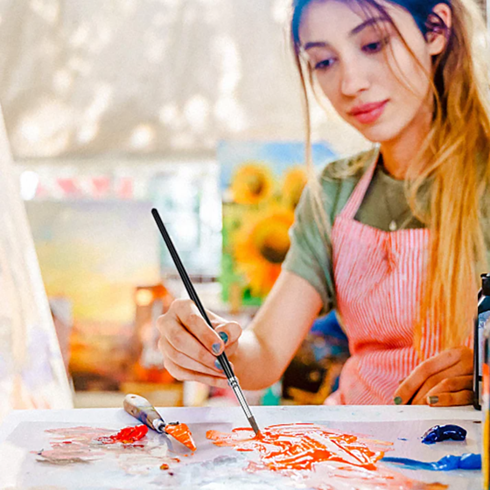 A young artist using a squirrel hair brush and palette knife to mix and apply acrylic paint, ideal for professional or beginner use.