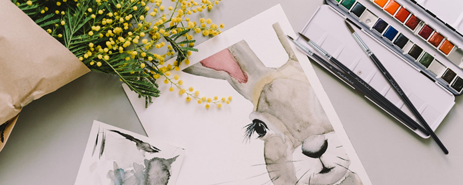 Professional Squirrel Hair Watercolor Brush set and watercolor paint set beside a rabbit illustration on cold press paper. High-quality artist tools for professional artists and beginners.