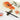 Pinceau Fuumuui en poils d'écureuil gris avec pointe souple, manche lisse et cordon de suspension, reposant sur un porte-pinceau en pierre à côté de peintures de fleurs à l'aquarelle vibrantes et d'un plat de peinture orange.