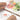 Fuumuui 100% Cotton Watercolor Block with a hand separating a vibrant floral watercolor painting, demonstrating the glue-free gap for easy paper removal.