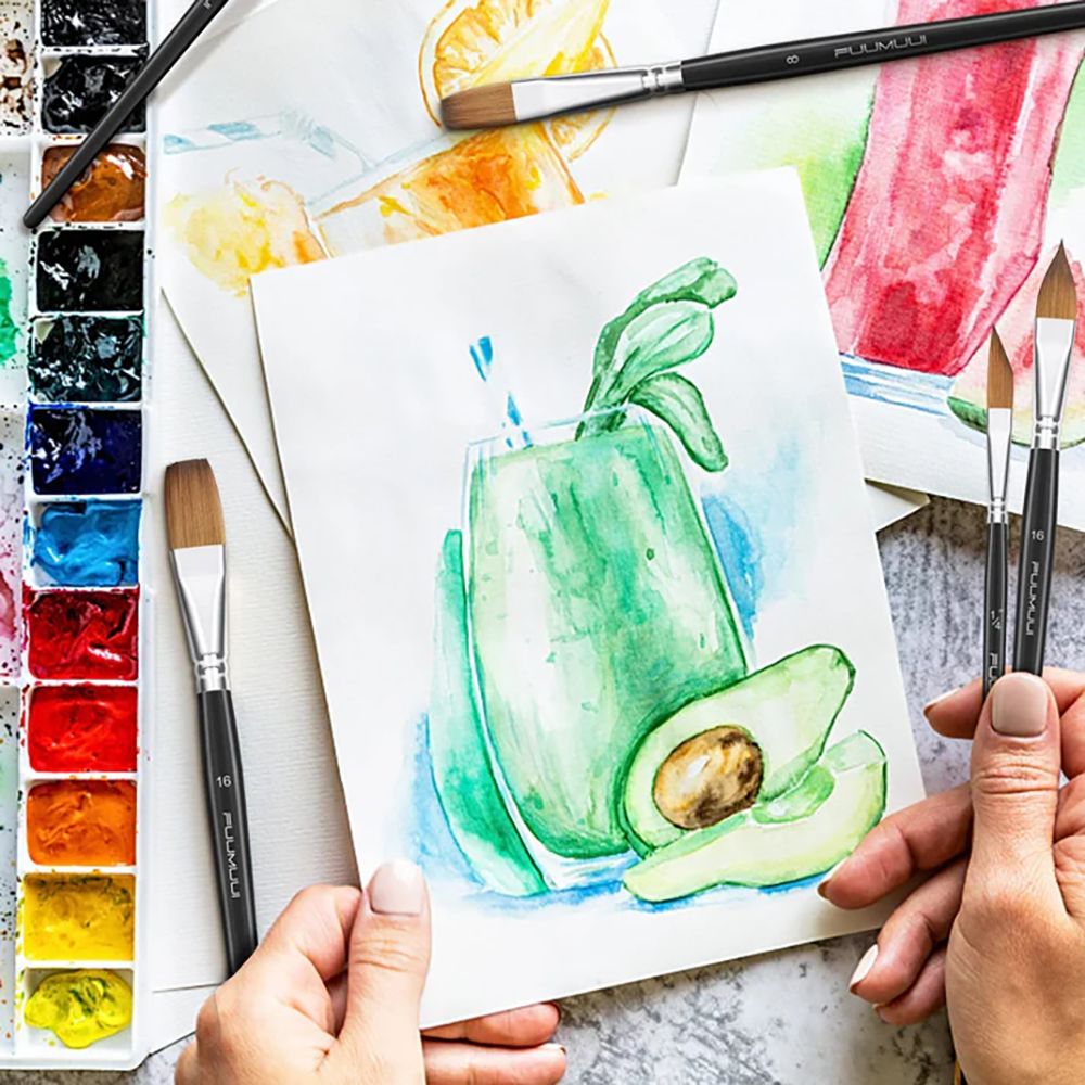 An artist painting with professional watercolor brushes, creating a vibrant painting of an avocado with a green smoothie.