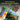 Fuumuui Ensemble de peinture gouache dans un étui portable, comprenant 24 couleurs de godets de gelée vibrantes, une palette d'artiste avec des peintures mélangées et plusieurs pinceaux à côté d'une peinture de paysage colorée.