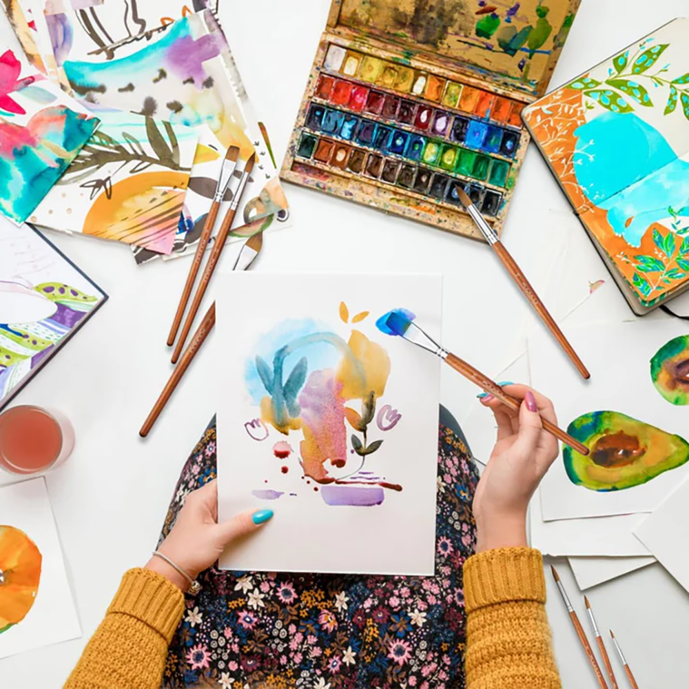 An artist paint flowers with a sable paint brushes.