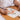 Fuumuui professional watercolor brush in use, painting an orange floral design.