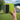 Portable lime green watercolor sketchbook and black metal travel palette held in hand. Ideal art supplies for plein air painting and travel. Features 140lb 300gsm cold press paper for professional artists.