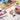 Ensemble de pinceaux de mélange acrylique professionnels Fuumuui & Samantha Anderson avec des manches roses en cours d'utilisation, peignant une rose à côté d'une palette d'artiste avec des peintures acryliques vibrantes et un couteau à palette Fuumuui.