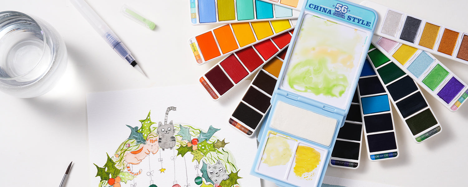 Fuumuui 56-color china style travel watercolor set open beside a painted Christmas wreath illustration.