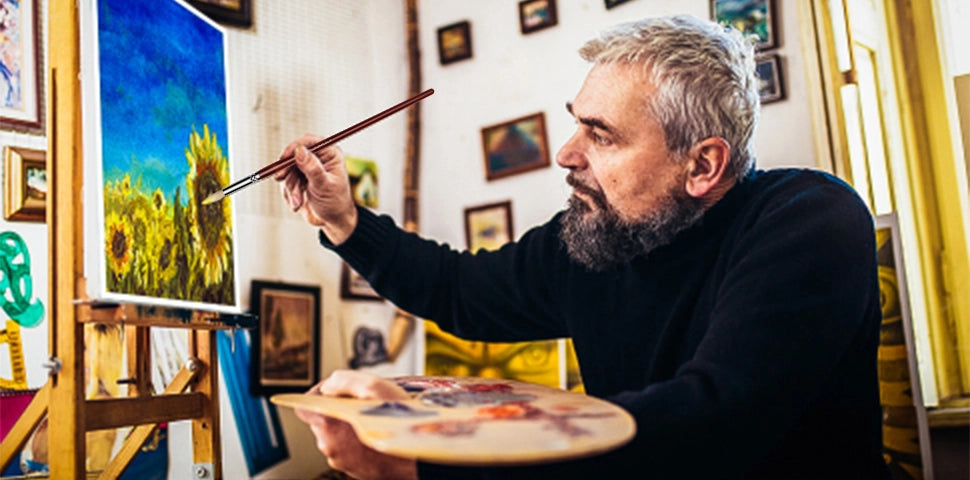 Professional artist in a studio using a long-handled natural bristle oil paint brush to paint sunflowers. Versatile bristle brushes for oil paint and acrylic paint, perfect for professional artists and beginners.