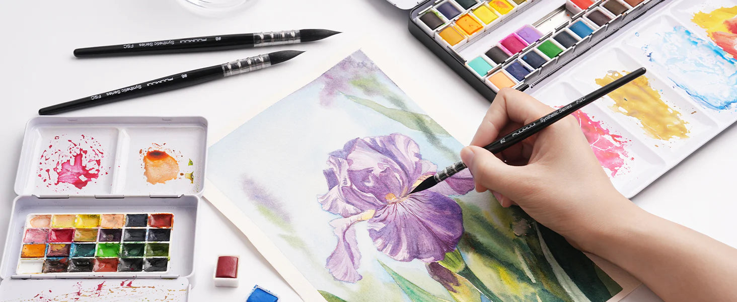 Fuumuui synthetic squirrel hair watercolor brush set with sizes #2, #6, and #8. An artist uses the #2 detail brush to paint a purple iris on textured paper next to a professional watercolor paint set.