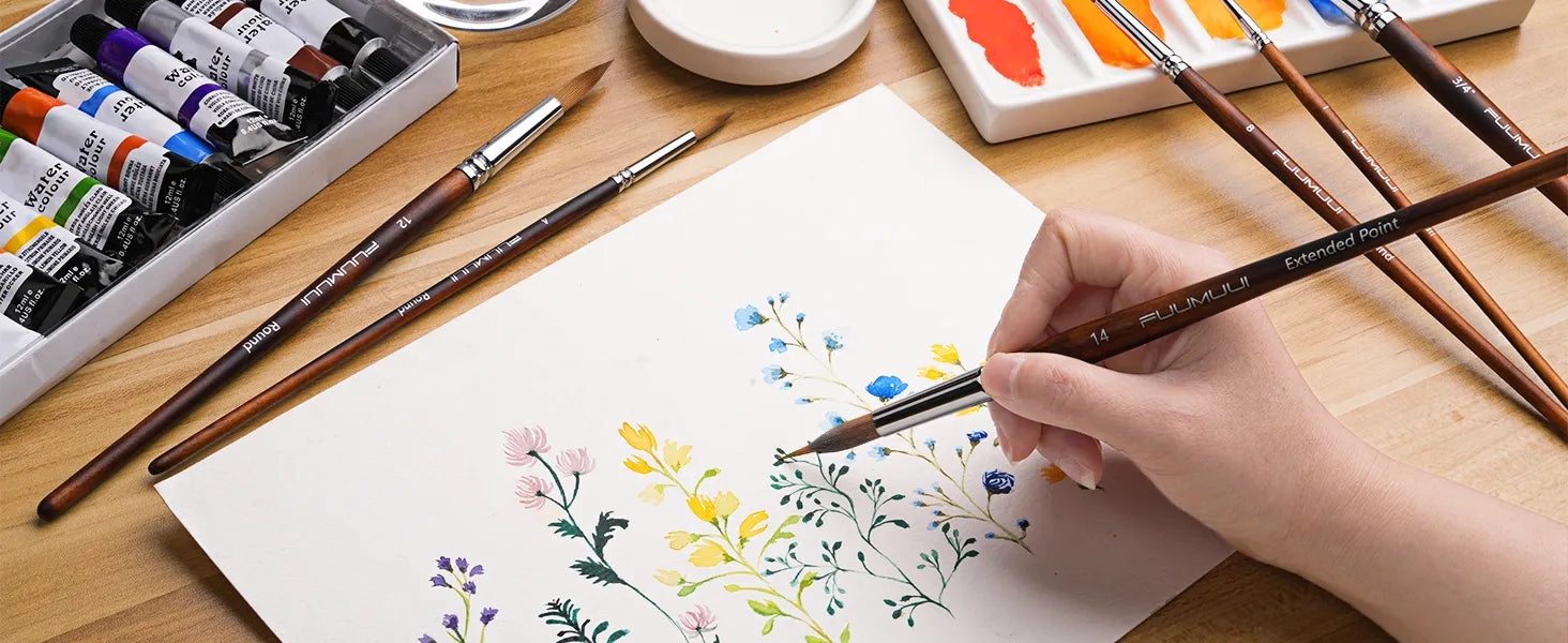 Professional artist using a size 14 extended point needle tip brush for floral painting on cold press paper. Fuumuui watercolor brush set includes squirrel hair mop, round brushes, and watercolor paint set tubes.
