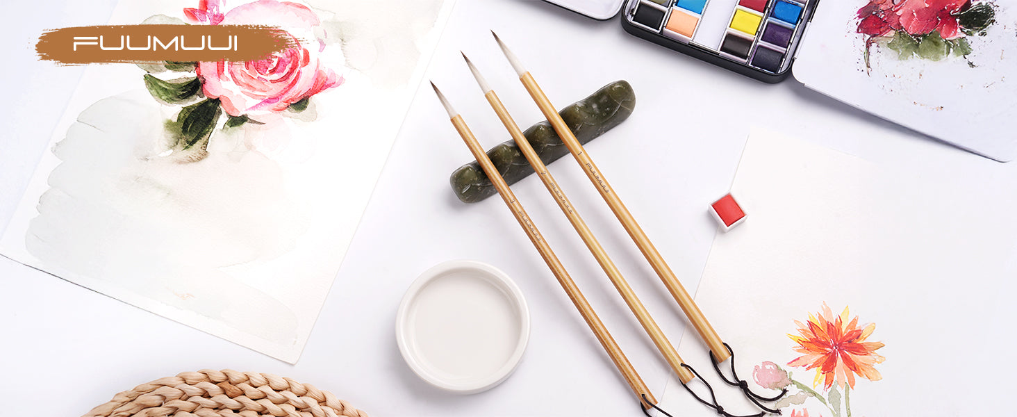 Fuumuui Chinese Calligraphy Brush set with wolf and sheep hair mix on a stone rest, accompanied by a watercolor paint set and floral paintings on textured cold press paper for professional artists and beginners.