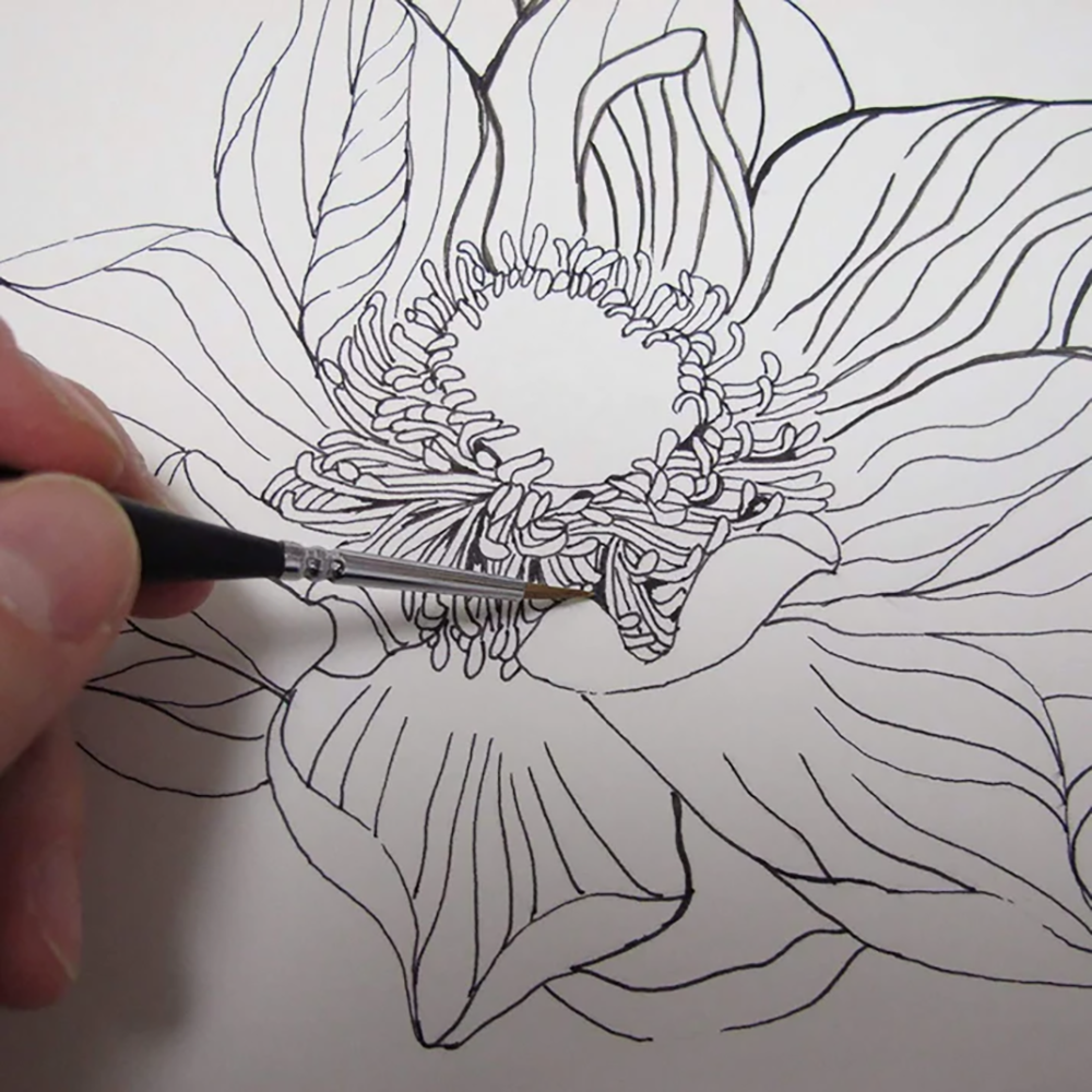 A fine detail paint brush is used to add intricate black ink lines to the center of a floral sketch, showing the precision of the miniature art brush.