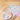 Fuumuui color wheel watercolor palette next to two paintbrushes and a vibrant pastel artwork on wood.