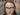 Portrait of a professional artist wearing black-framed glasses and silver earrings, representing the creative community and target audience for Fuumuui Art supplies.