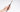 Hand holding a Fuumuui size 12 sable watercolor brush with an ergonomic matte black wooden handle.