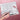 Fuumuui white plastic paint palette with lid open, featuring mixing wells and paintbrush storage, held by a person for watercolor painting.