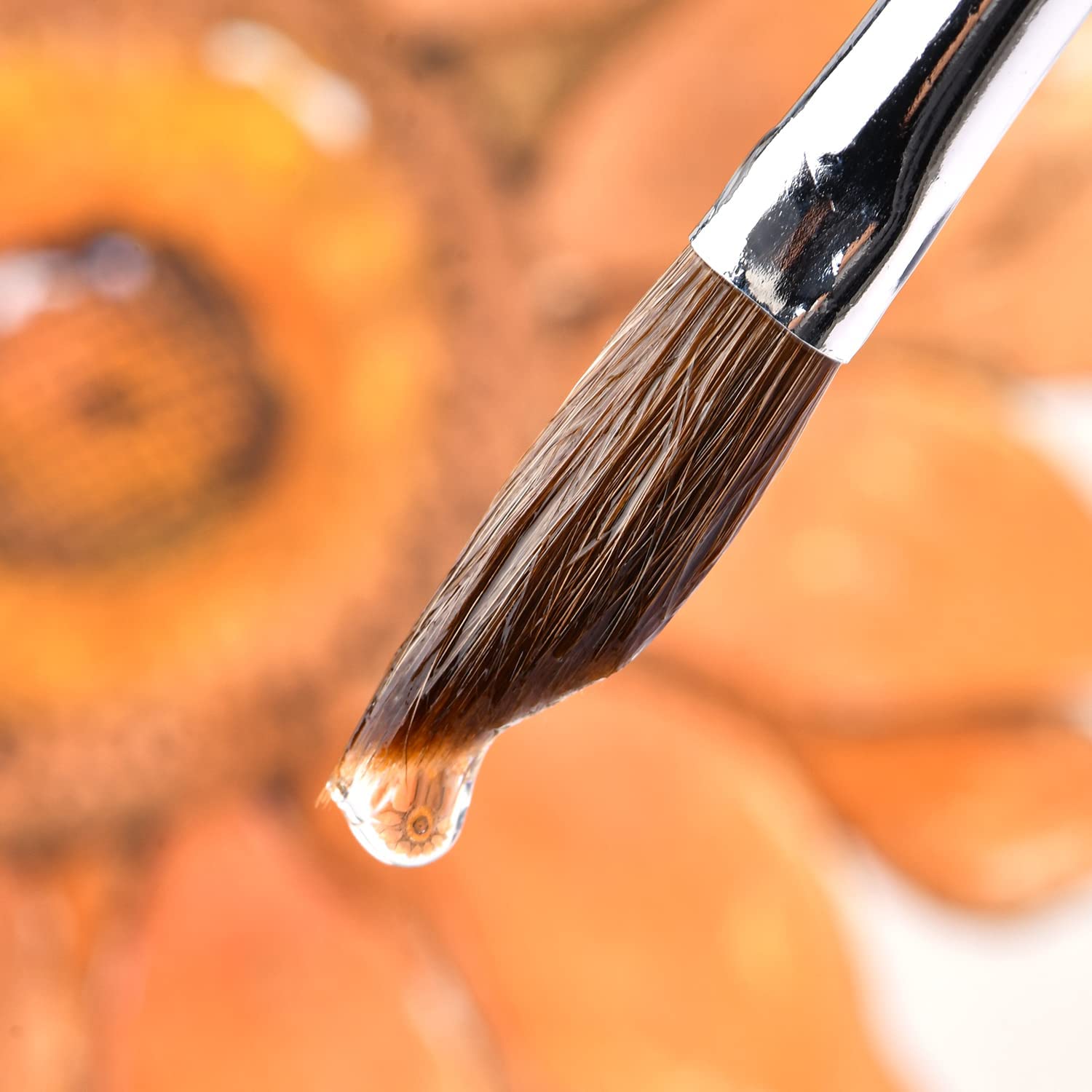 A sable watercolor brush tip holding a droplet of water, excellent water-carrying capacity.