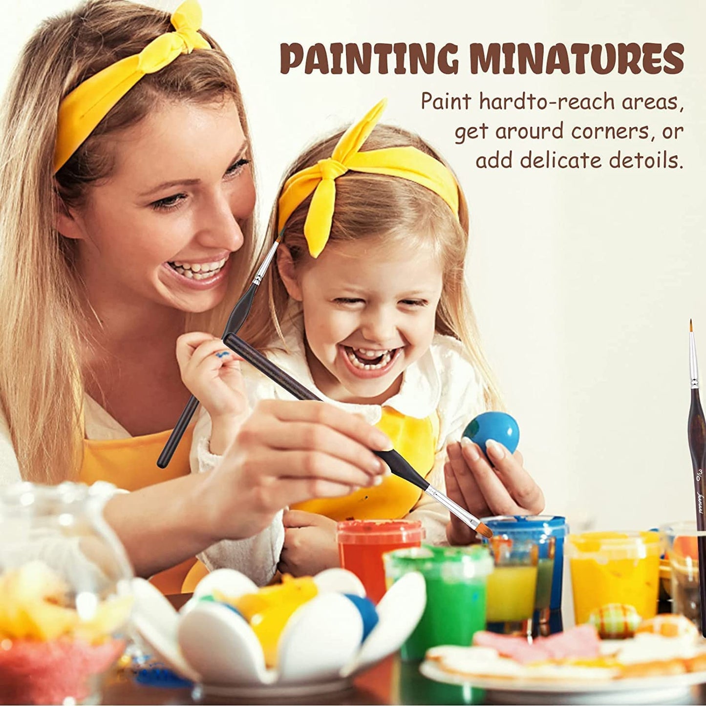 A woman and a child using a Fuumuui fine detail brush to painting miniatures.