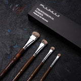 Set di pennelli Filbert FUUMUUI da 4 pezzi con setole di tasso, manici in legno marrone e ghiere argentate per pittura a olio e acrilico, esposto con la confezione della serie professionale Fuumuui.