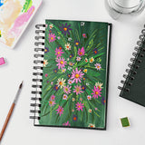 Fuumuui Watercolor Sketchbook, spiral bound with 100% cotton paper, displaying a vibrant floral watercolor painting, surrounded by Fuumuui art supplies including a brush and palette.