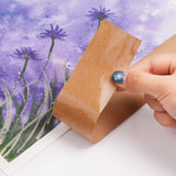 A hand removing Fuumuui Kraft Water-Activated Paper Tape from a finished watercolor painting of purple flowers, showcasing its strong wet adhesion and no residue after drying.