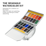 Kit acquerello portatile Fuumuui aperto, che mostra la sua tavolozza da viaggio a 24 colori con godet di pittura vibranti, aree di miscelazione integrate e spugna per artisti che praticano la pittura ad aria aperta, lo sketching urbano o il journaling di viaggio.