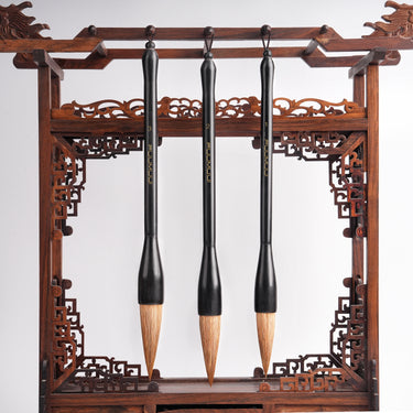 Fuumuui professional large-size calligraphy brushes for watercolor and ink painting, displayed on an intricately carved wooden stand.