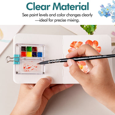 Fuumuui transparente, tragbare Aquarellfarben-Palette und Reisefarbpalette mit mehreren Farbnäpfen und einem Mischbereich mit roter Farbe. Ein Künstler verwendet Fuumuui Künstlerbedarf, um eine Blume auf ein Skizzenbuch zu malen, wobei das transparente Material für präzises Mischen von Aquarell-, Gouache- oder Acrylfarben zur Geltung kommt.