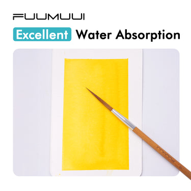 FUUMUUI Aquarellpostkarten, 100% Baumwolle und kaltgepresst, demonstrieren eine ausgezeichnete Wasseraufnahme mit einer lebendigen gelben Aquarellwäsche. Ein FUUMUUI-Kunstbedarf-Pinsel wird auf dem Papier gezeigt.