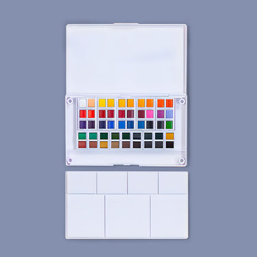 Set di colori ad acquerello Fuumuui da 48 colori con la sua custodia bianca aperta, che rivela 48 vivaci cialde di acquerello e una tavolozza di miscelazione bianca separata.