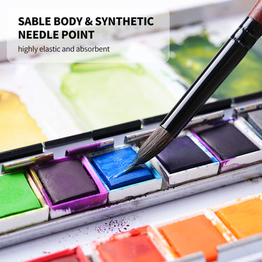 Fuumuui Travel Watercolor Brush with Sable Body & Synthetic Needle Point, highly elastic and absorbent, dipping into vibrant blue watercolor paint. Ideal for professional plein air gouache and ink painting.