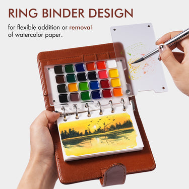 Fuumuui Watercolor Travel Set showcasing its refillable ring-bound design with a brown PU leather cover, vibrant premium watercolor paints, and 300gsm cotton paper, as a hand swatches colors with the double-ended brush.
