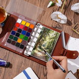Fuumuui Watercolor Travel Set featuring a PU leather cover, open to reveal premium watercolor paints and refillable ring-bound 300gsm cotton paper, with an artist using the Fuumuui double-ended travel brush to paint a forest scene.