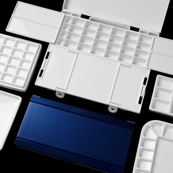 Durable white plastic palette with multiple wells and mixing areas for watercolor paint or gouache. Portable travel palette with a sleek blue lid, perfect for professional artists and beginners.