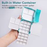 Boîte de palette d'aquarelle pliante double couche Fuumuui ouverte, tenue dans une main, présentant 24 godets, 7 zones de mélange et le récipient d'eau intégré innovant parfait pour le rinçage des pinceaux, ce qui en fait un plateau de peinture Fuumuui Art Supplies compact et portable pour les voyages et l'utilisation en studio.