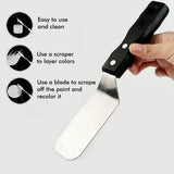 Coltello da pittura Fuumuui Art Supplies in acciaio inossidabile con manico in legno scuro, tenuto da una mano, che evidenzia la sua versatilit¨¤ come spatola per una facile miscelazione, stratificazione dei colori e raschiatura di colori a olio e acrilici.