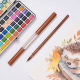 FUUMUUI Handgefertigter Tierhaarkalligraphiepinsel mit Magnetkappe, ausgestellt neben einem Aquarellfarbenset und einem Igelgemälde, der Fuumuui Kunstbedarf zeigt.