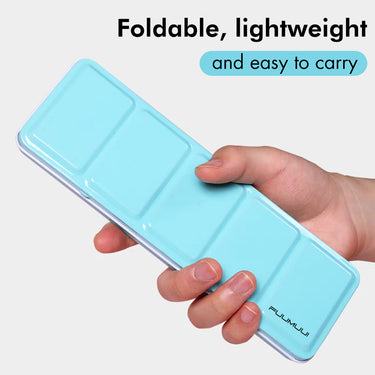 Fuumuui 24-Farben Aquarellfarben-Set in einem kompakten hellblauen Koffer, der von einer Hand gehalten wird und sein faltbares, leichtes und einfach zu transportierendes Design hervorhebt.