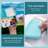 Boîte de palette d'aquarelle pliante à double couche Fuumuui avec 24 godets et 7 zones de mélange séparées, tenue ouverte dans une main avec un pinceau, démontrant sa conception compacte de la taille d'une paume pour les voyages portables et l'utilisation en studio, également montrée se glissant facilement dans une poche.